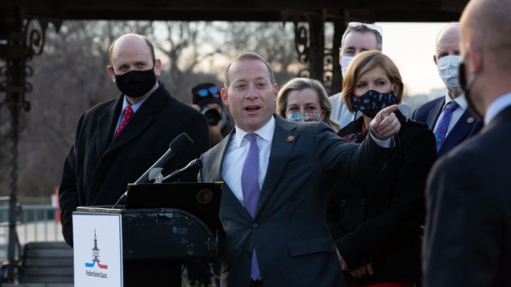 Rep. Josh Gottheimer (D-NJ) speaks at the podium standing with members of the Problem Solvers Caucus.